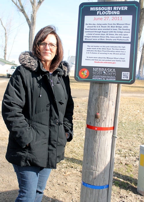woman pictured next to historical flood marker