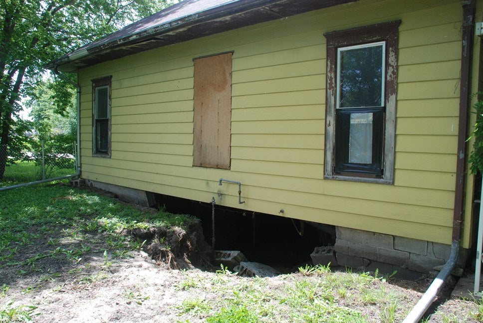 house with hole dug under the side of it