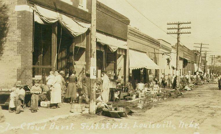 old photo of town and people standing on the street