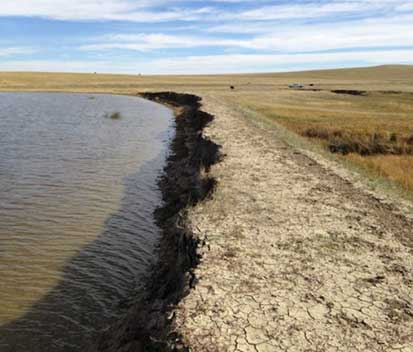 Image of a dam beside a field