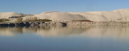 sand dunes with body of water